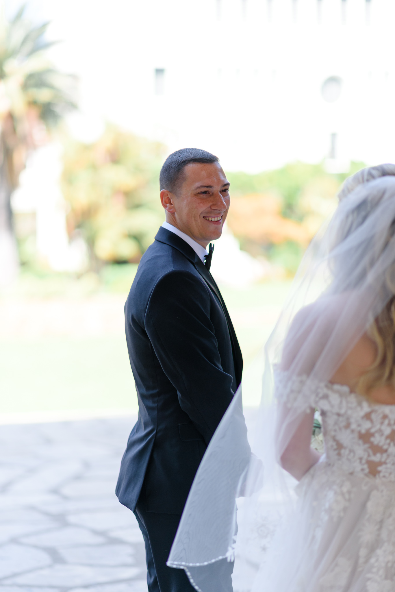 Groom in a black suit smiling during the wedding